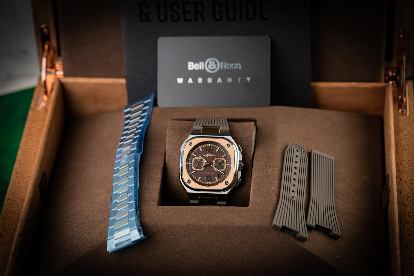 Bell & Ross watch with additional straps in a box, featuring a warranty card.