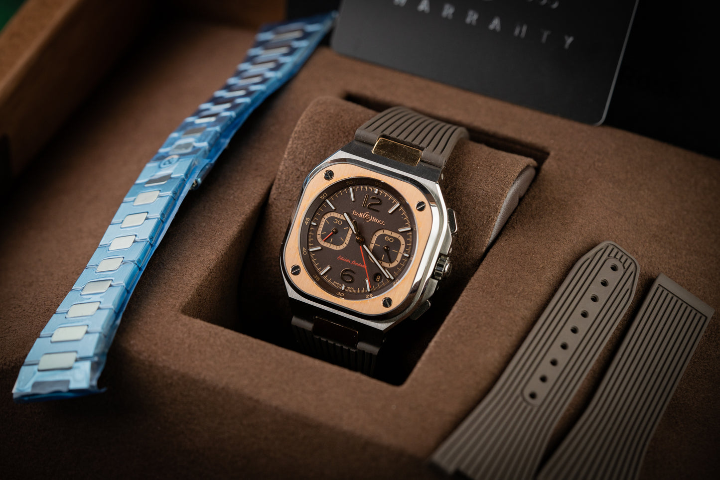 Luxury watch with blue and brown straps in a box
