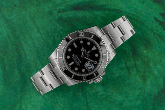 Pre-owned Rolex Submariner displayed on green background - Best Pre-Owned Rolex Dealers Sydney 2026 - The Watch Business