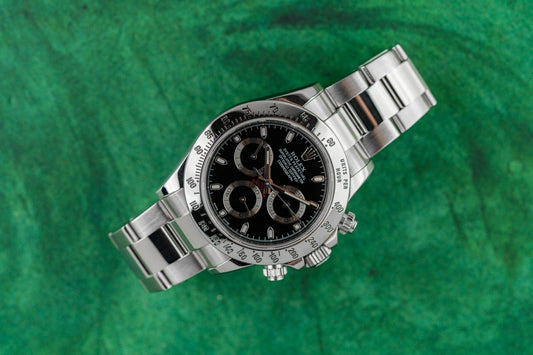 Rolex Daytona 116520 black APH dial stainless steel 2014 on green background - The Watch Business Sydney