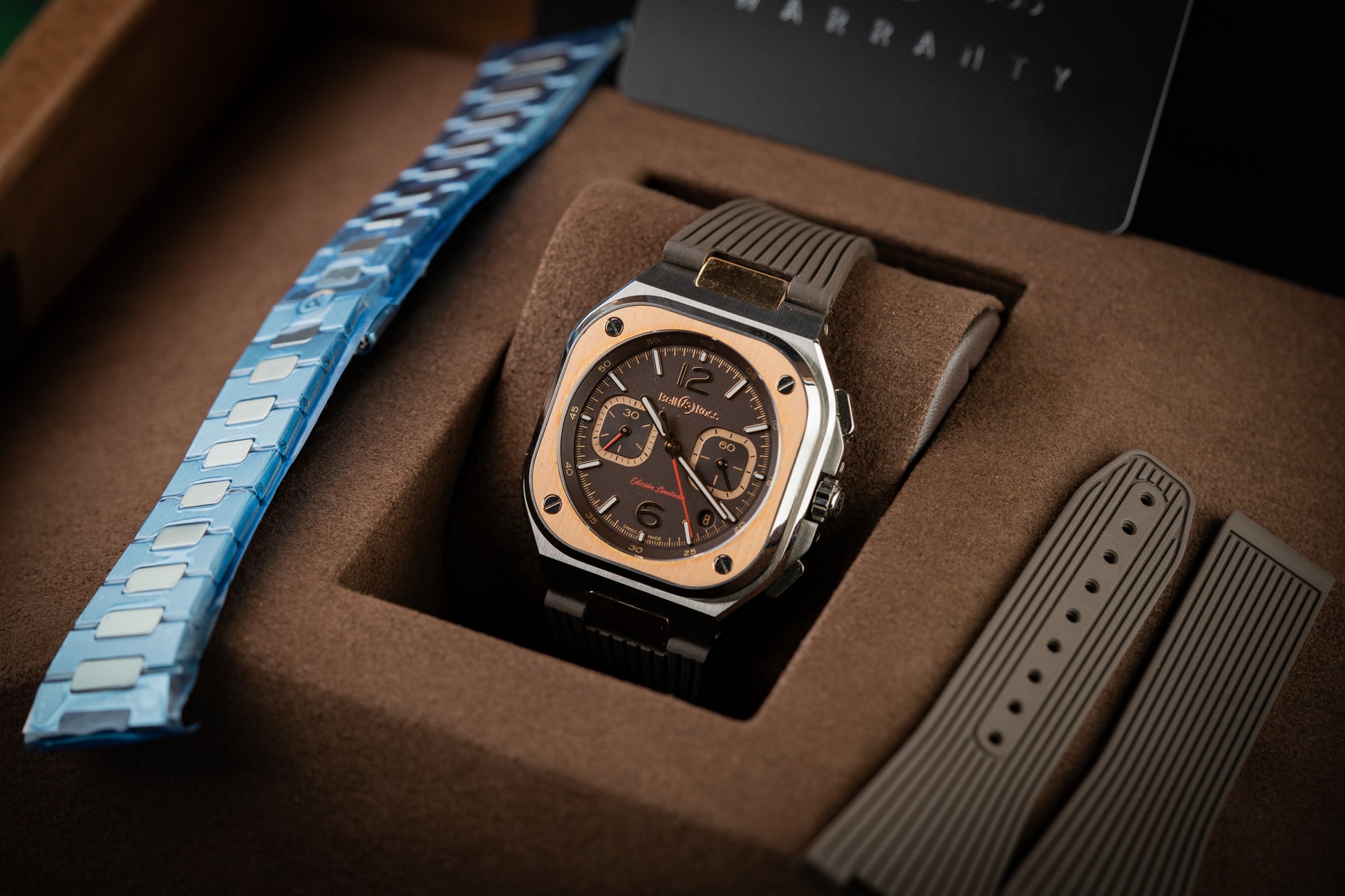 Luxury watch with blue and brown straps in a box