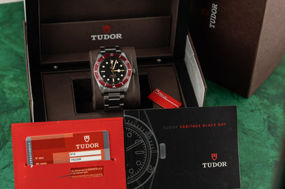 Tudor watch in an open box with packaging materials on a green surface